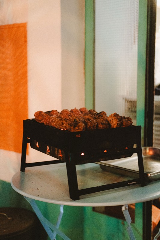 Les saucisses de bête rousse sur un petit brasero posé sur une table ronde