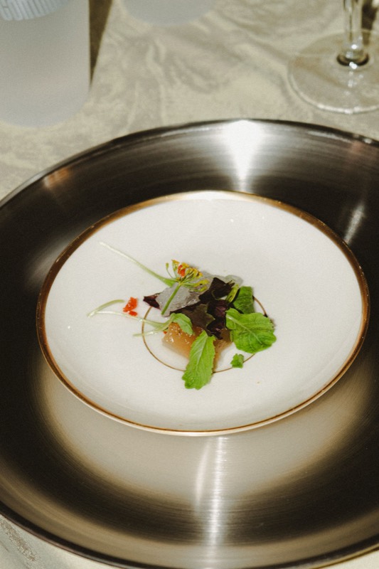 Le xholodetz dans une assiette blanche à liseré doré, posée sur un plateau en métal