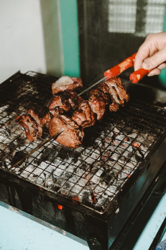 Brochettes de chevreuil retournées à la pince sur la grille