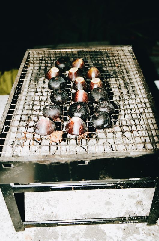 Figues posées face coupée sur la grille d'un petit barbecue à charbon